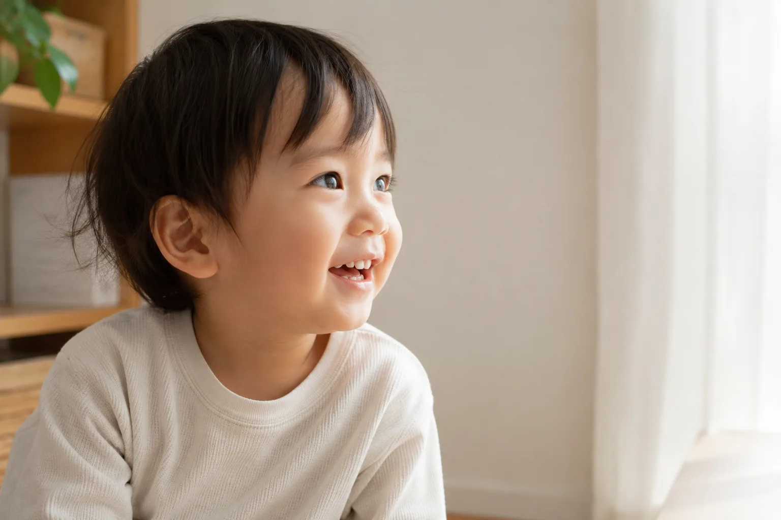 子ども写真の作例。子どもの目線の高さで撮り、表情に寄って視線の先に余白を取った構図イメージ。