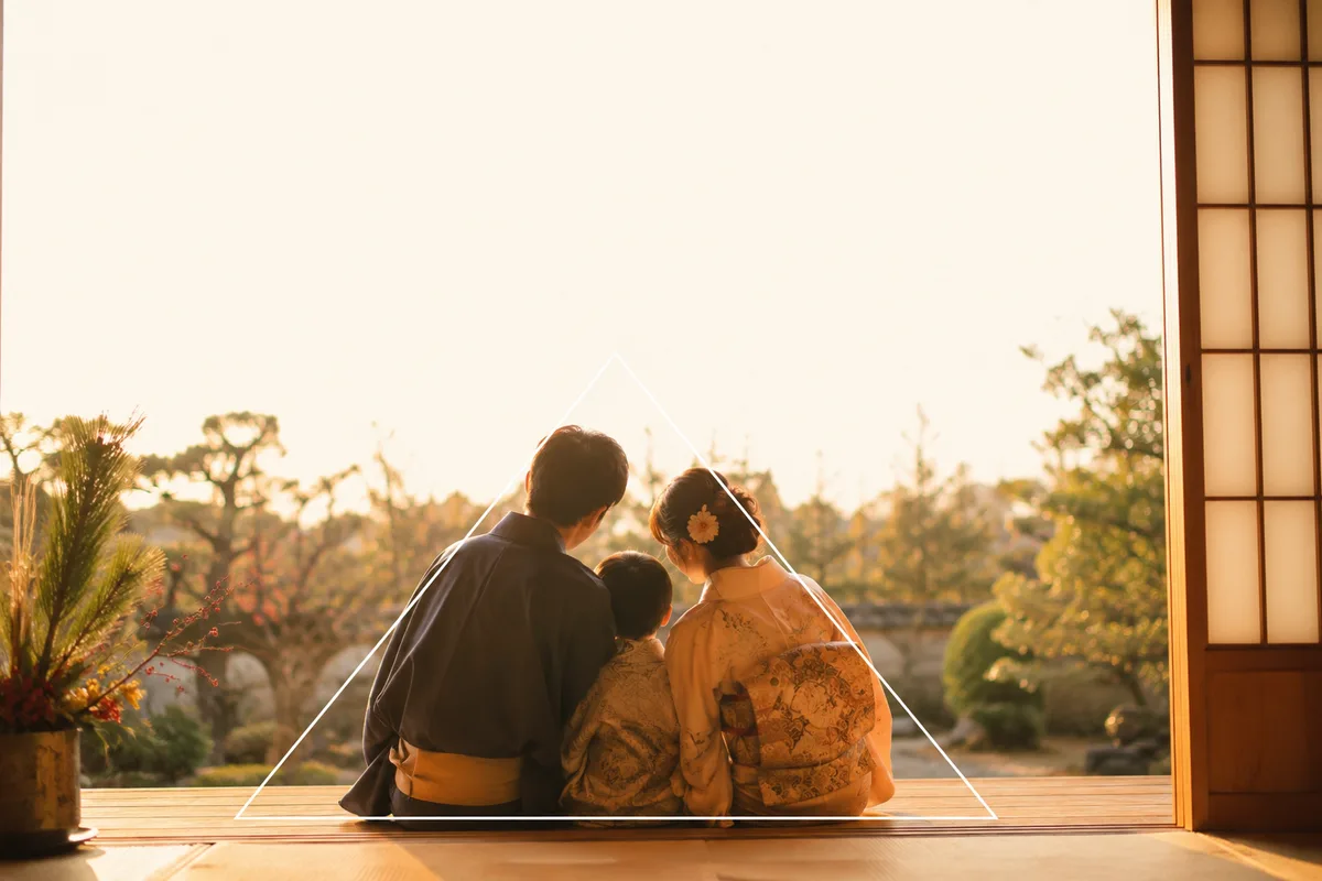 三角形構図の作例。座った親と子どもで三角形をつくり、上部にあいさつ文用の余白を残した家族写真の構図イメージ。